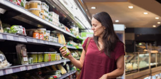 Woman checking food label in supermarket