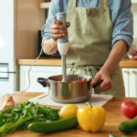 Man using a hand blender to prepare a meal