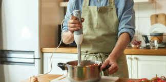Man using a hand blender to prepare a meal