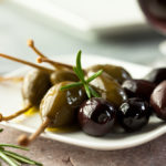 Caper berries and olives on a plate