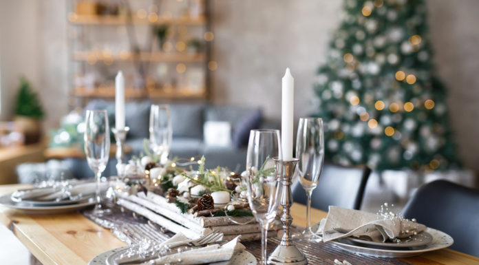 Table set with festive adornments and christmas tree in background
