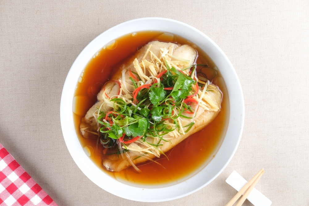 Steamed fish in broth with herbs