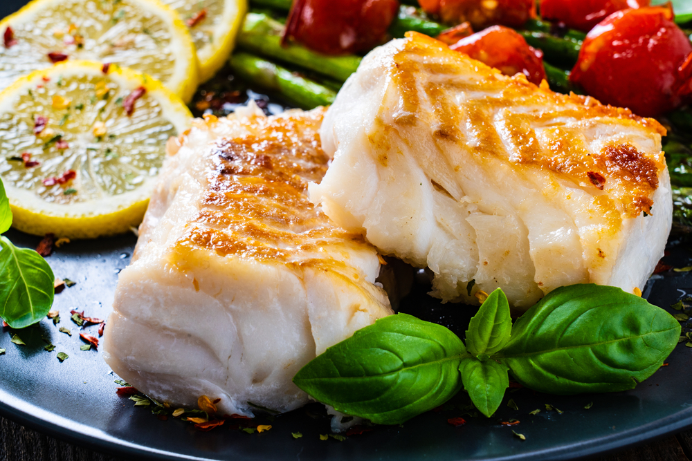Seared fish with lemon slices and herbs